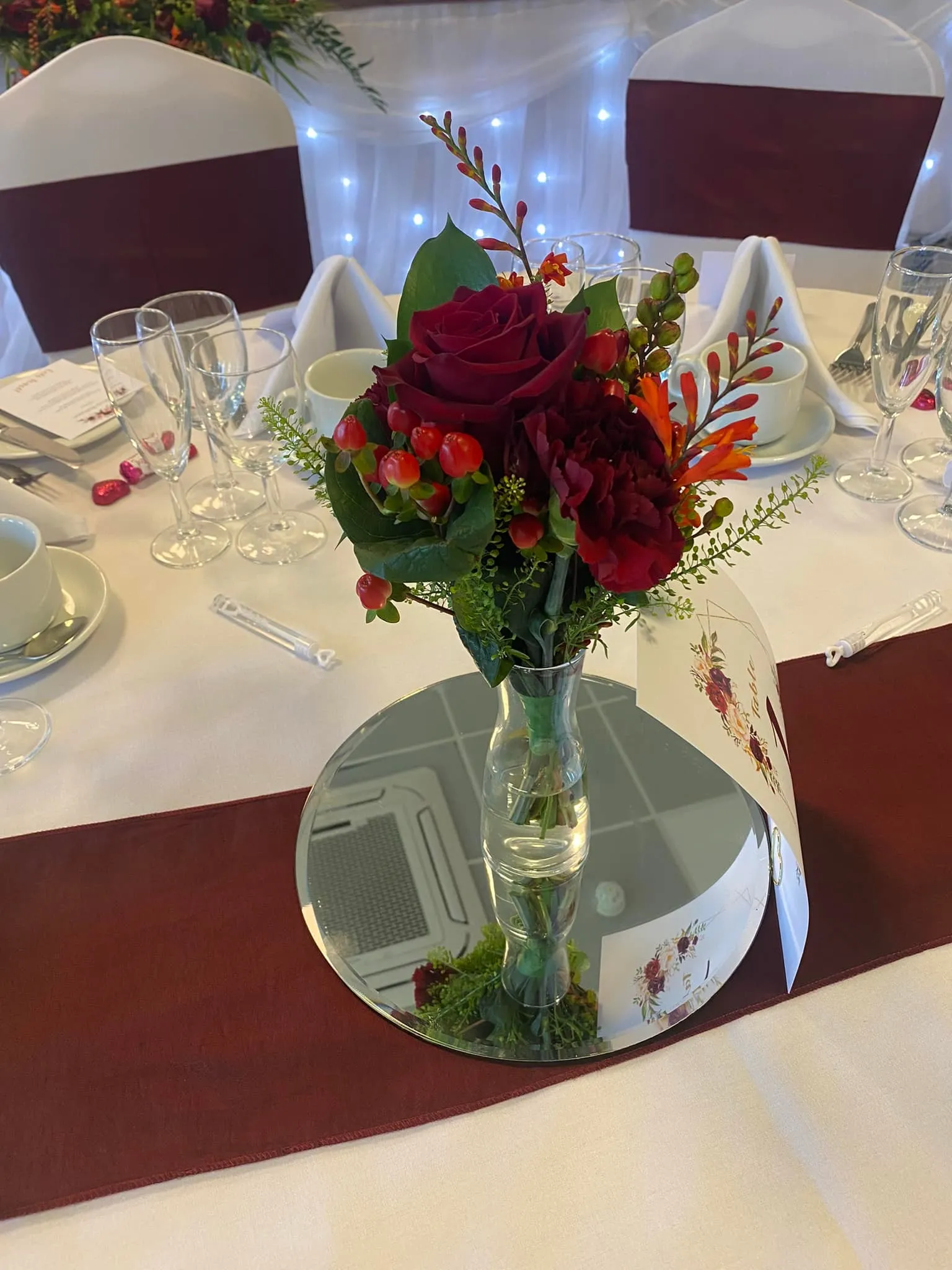 A vase filled with red flowers on top of a table.