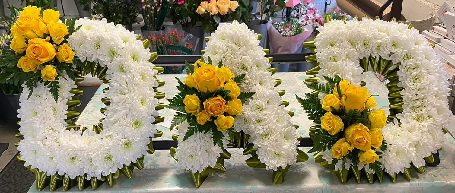 A table topped with white and yellow flowers.
