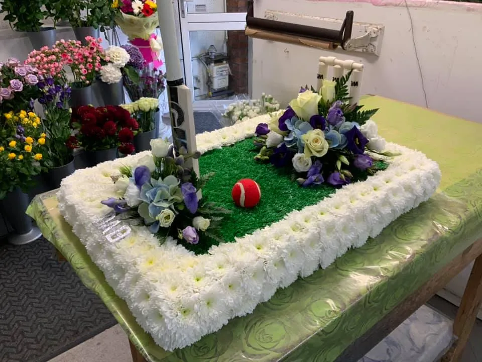 A cake with flowers and a golf ball on it.