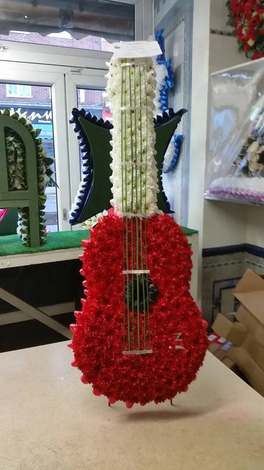 A guitar made out of flowers on a table.