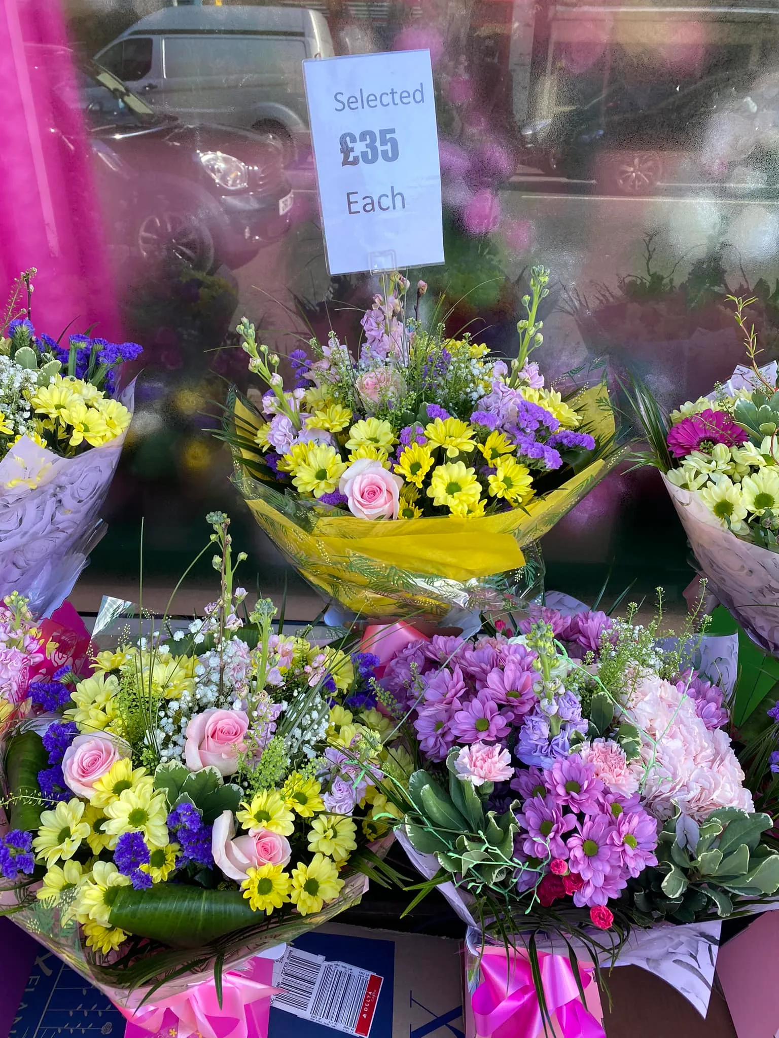 there are many different flowers on display in a store window