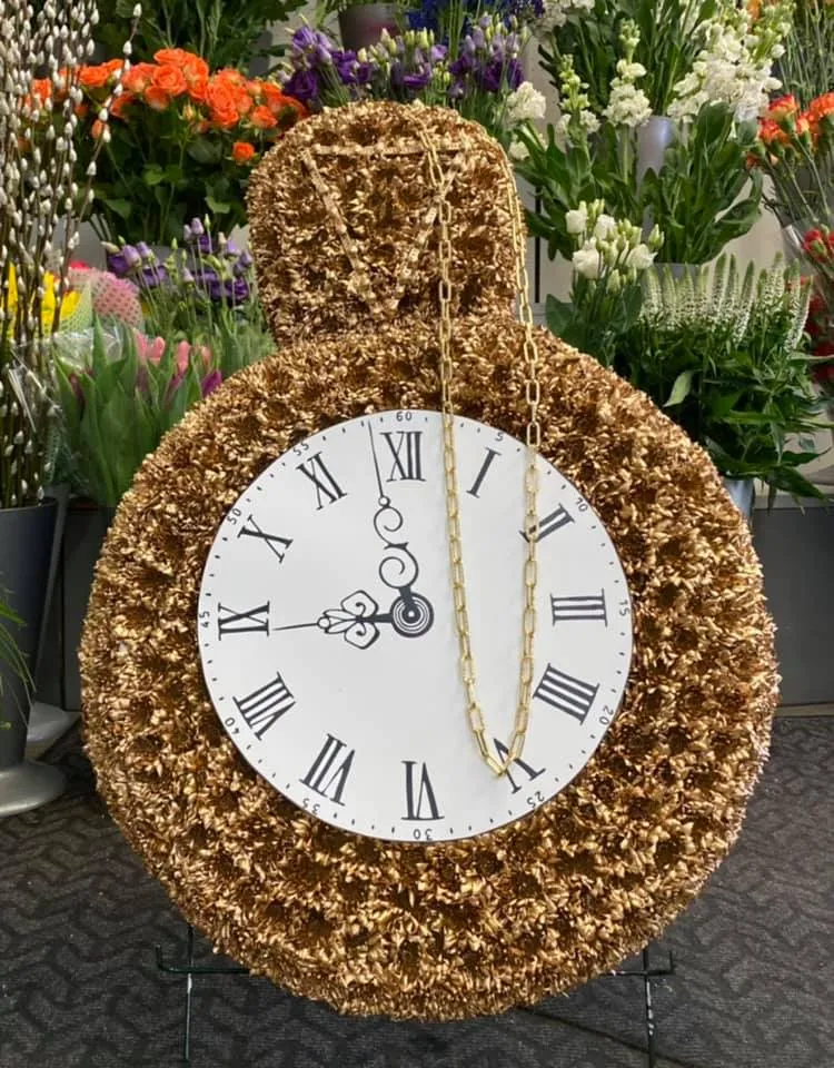 a clock made out of flowers in a garden