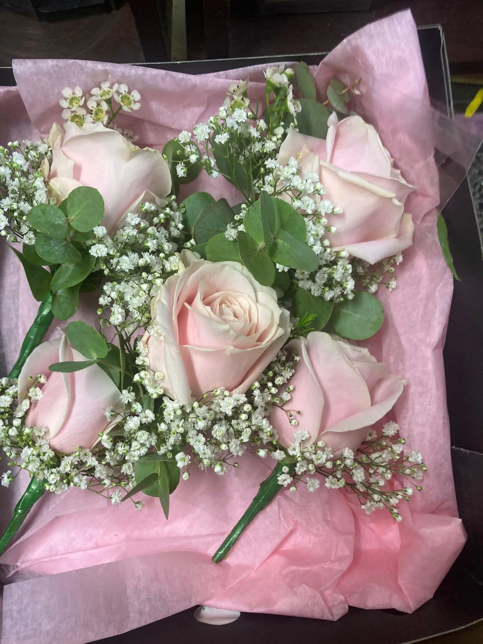 A bouquet of pink roses and baby's breath.