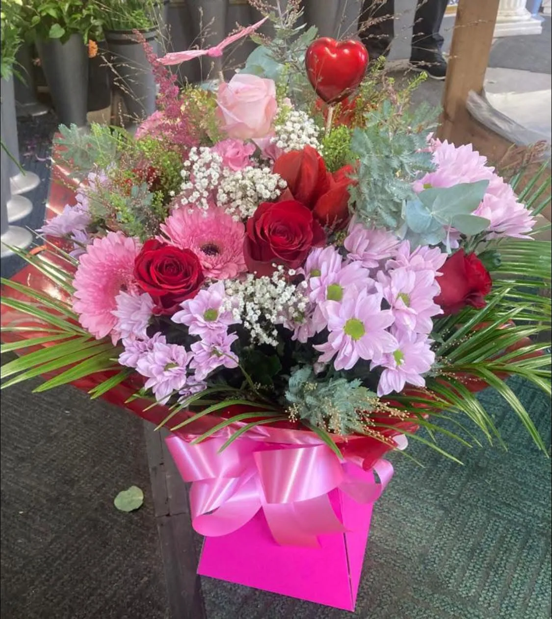 A bouquet of flowers in a pink box.